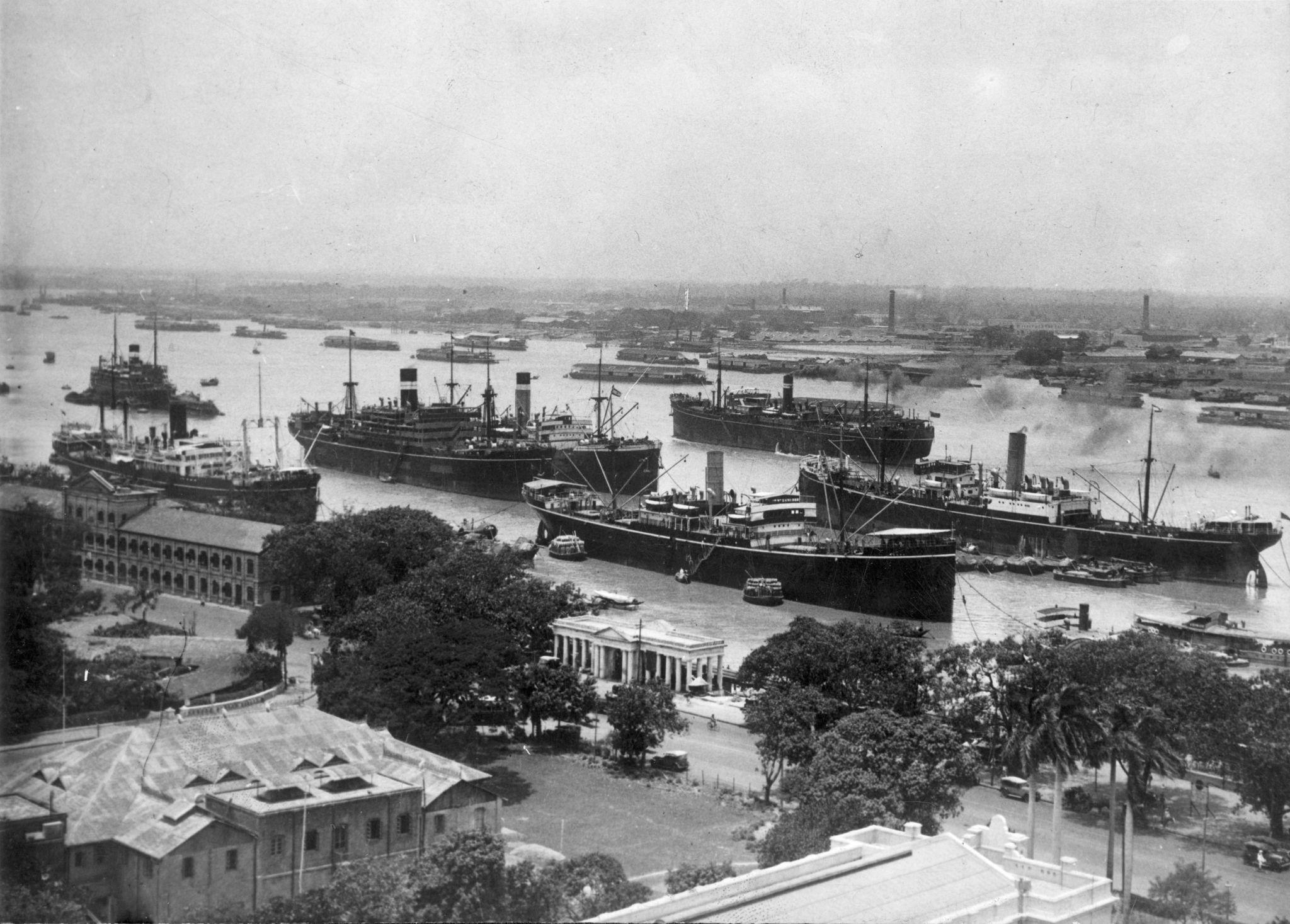 : Historic aerial view of Calcutta port with multiple steamships docked along the Hooghly River during the colonial era,